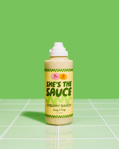Bottle of She's the Sauce Creamy Ranch on a green tiled surface